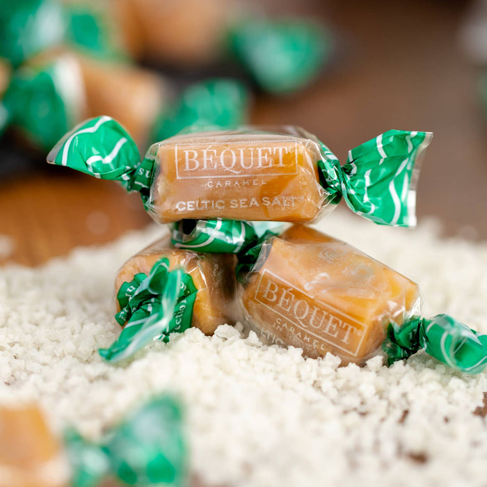 Béquet caramel candies with green wrappers on a white surface