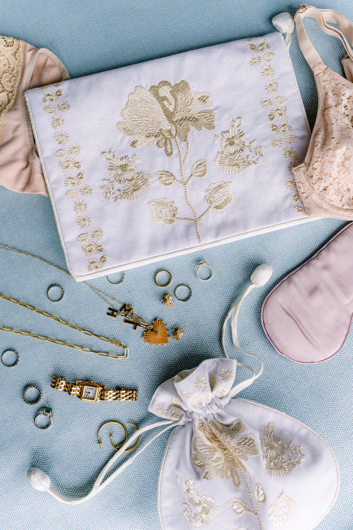 Peony lingerie envelope and jewelry pouch arranged with accessories on blue fabric by Lenora