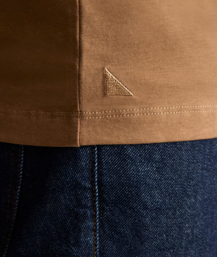 Model is wearing UNTUCKit EcoSoft Short-Sleeve Henley in toasted coconut.