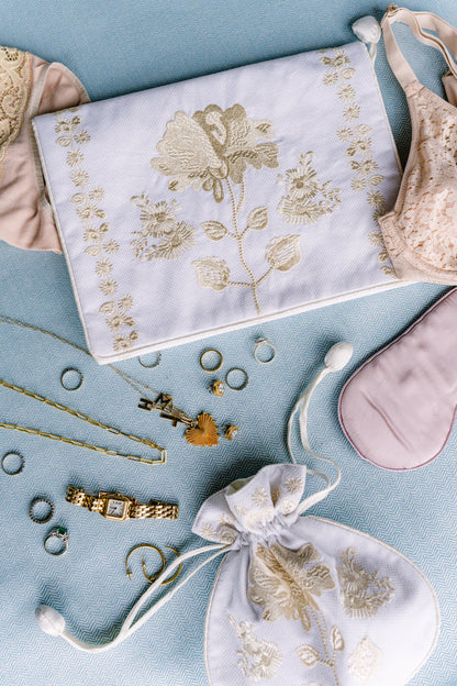 Peony lingerie envelope and jewelry pouch arranged with accessories on blue fabric by Lenora